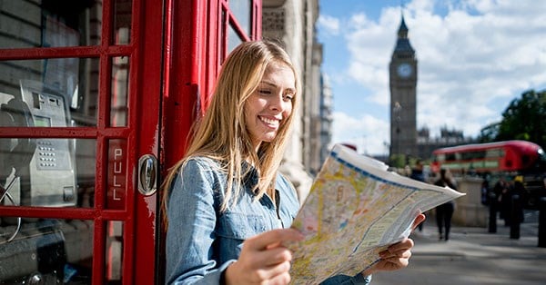 Dame i London lener seg mot en telefonkiosk fremfor Big Ben og holder et kart, til illustrasjon for kortvettregler