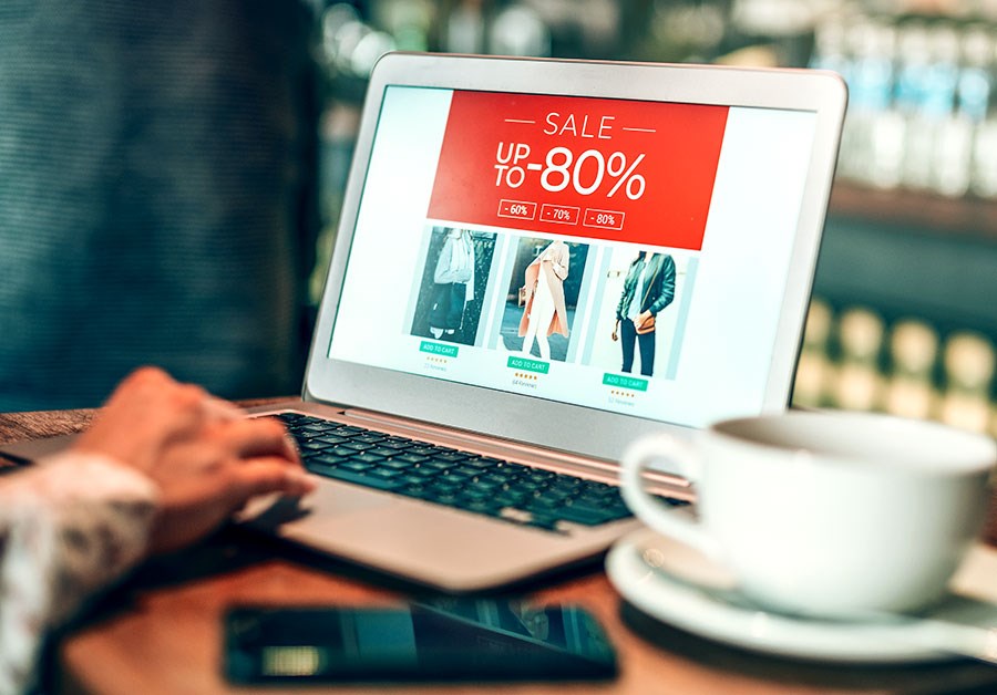 Mann sitter på kafé og ser på salg på en nettside, til illustrasjon for kredittkort fordeler