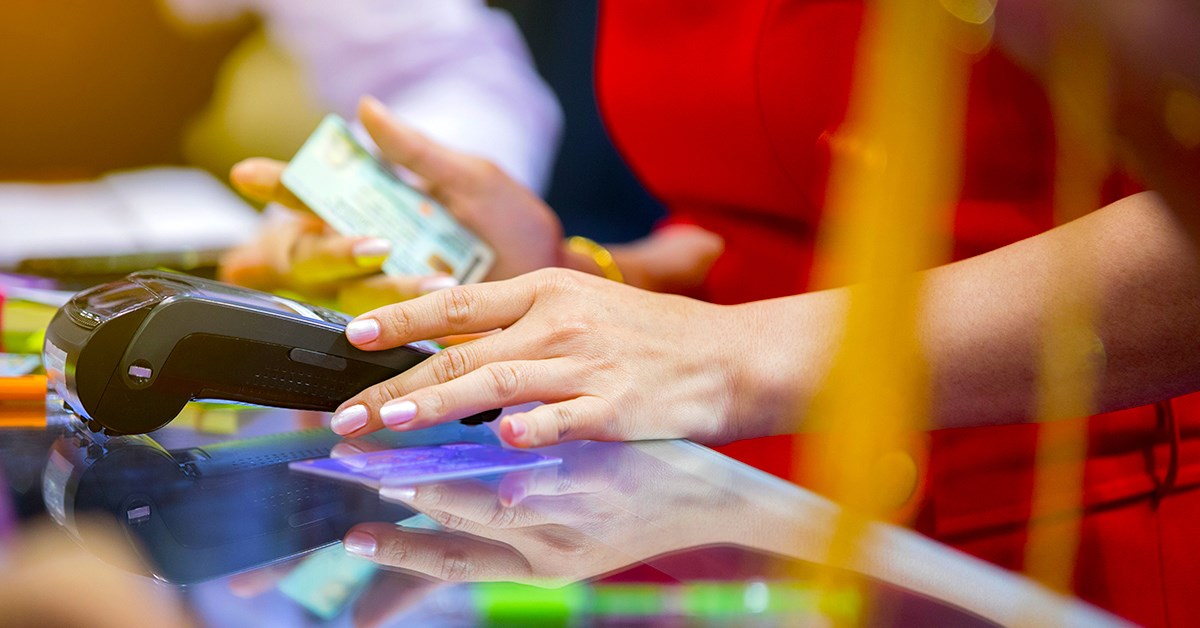 Kvinne betaler i lokal valuta med bankkort i utlandet