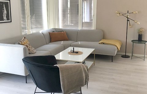 Moderne stue i leilighet med sofa, sofabord og stol, til illustrasjon for drømmen om egen bolig