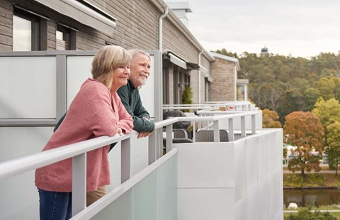 Par står på balkongen og ser utover