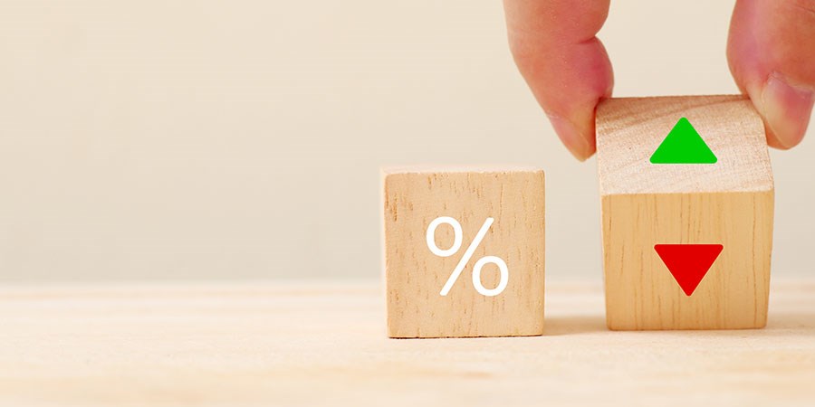 Person holder klosse med pil opp og ned, samt en klosse med prosenttegn, til illustrasjon for renteendring